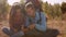 Caucasian man and woman listen to music on a mountain hike using a smartphone and headphones.