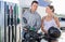Caucasian man and woman refuelling motorbike in gas station