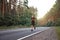 Caucasian middle age man athlete runs sunny summer day on asphalt road in the forest