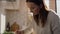 Caucasian middle age woman standing in kitchen and making a soup.