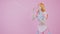 Caucasian Model Flirts With Camera By Slowly Blowing Shiny Bubbles Medium Long Studio Shot Pink Background