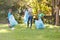 Caucasian mother, son and daughter putting rubbish in refuse sacks in the countryside