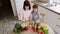 Caucasian mother teach little preschooler daughter chop vegetables preparing salad for lunch