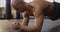 Caucasian muscular shirtless bald man exercising and doing plank