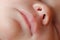Caucasian Newborn baby face closeup macro detail shot. child portrait, health skin, tenderness, maternity and babyhood concept -