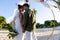 Caucasian newlywed couple with face to face holding hands and standing at beach wedding ceremony