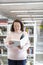 Caucasian older woman reading a book in a public library