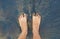 Caucasian person feet foot standing on black volcanic sandy beach