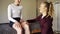 Caucasian physiotherapist assesses knee flexibility of young female patient