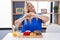 Caucasian plus size woman eating breakfast at home smiling in love doing heart symbol shape with hands