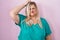 Caucasian plus size woman standing over pink background confuse and wondering about question