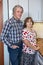 Caucasian positive retirement mature couple standing beside kitchen countertop and looking at camera