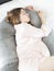 Caucasian pregnant woman sleeping in a pregnancy pillow . Comfort sleeping in pregnancy. Maternity body pillow