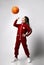 Caucasian preteen girl model in fashion tracksuit playing with basketball ball