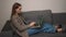 Caucasian pretty young woman typing on laptop with green screen, lying on the couch sofa at the home. Chromakey