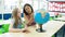 Caucasian primary school girl and her teacher looking at a globe