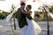 Caucasian romantic newlywed couple dancing at beach at wedding ceremony during sunset