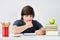 Caucasian school boy sit at the table and think with a serious and concentrated expression