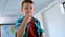 Caucasian schoolboy sitting over desk and counting with his finger in classroom