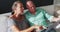 Caucasian senior couple sitting on sofa talking in the sun using laptop