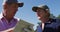 Caucasian senior couple writing golf score on scorecard at golf course on a bright sunny day