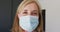 Caucasian senior female doctor wearing surgical gloves adjusting face mask