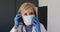 Caucasian senior female doctor wearing surgical gloves putting on face mask