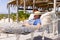 Caucasian senior man with hat on face sleeping on hammock at beach during sunny day