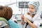 Caucasian seven year old girl switched roles with her dentist in a clinic or office. Child is wearing a medical uniform