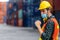 Caucasian shipyard worker in safety vest and helmet raise his fist to show how confidence to fight with