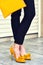 Caucasian slim elegant woman wearing suit yellow high heels and bag.