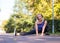 Caucasian smiling grownup woman doing exercise outdoor in fall in urban park, selective focus