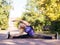 Caucasian smiling grownup woman doing workout outdoor in fall in urban park, selective focus