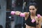 Caucasian strong young woman doing exercise with pink dumbbells. Fitness European female doing intense training in the gym club.