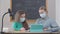 Caucasian student and tutor in coronavirus face masks sitting in classroom talking. Portrait of smart confident woman