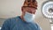 Caucasian surgeon male healthcare professional in a hospital operating theatre wearing a surgical cap and mask. Low