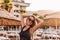 Caucasian tanned smiling young woman in sunglasses on the beach in the contra sunlight