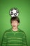 Caucasian teen boy with soccer ball on head.