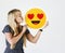 Caucasian teen holding falling in love emoji