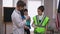 Caucasian teenage boy in doctor gown bandaging hand of friend in builder uniform. Positive confident teenagers choosing