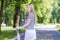 Caucasian Teenage Girl Posing With Long Skateboard in Green Forest.