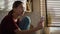 Caucasian teenager girl sitting in the kitchen and having video call on mobile phone