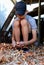 A Caucasian teenager peels onions, preparing them for the winter.