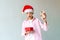 Caucasian teenager santa boy holding red-white christmas box with red silky