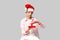 Caucasian teenager santa boy holding red-white christmas box with red silky