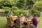 Caucasian three generation family holding hands saying grace before eating meal together in garden