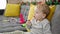 Caucasian toddler sitting on the sofa eating cookies at home