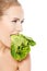 Caucasian topless woman with lettuce in mouth.