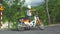 Caucasian tourist wearing a helmet sitting on a stylish motor cub in countryside