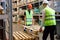 caucasian warehouse men hold cargo pallet together with co-worker in workplace area